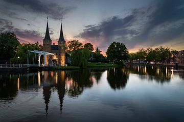 Gezicht op de Oostpoort, Delft bij zonsondergang van Jos Harpman