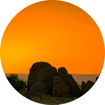 De zon gaat onder achter de rotsen in de Namib woestijn van Rietje Bulthuis