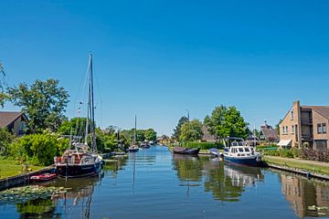 Boten in een kanaal in Workum in Friesland Nederland van Eye on You