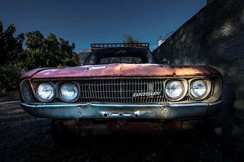 An abandoned classic Datsun 1500 pickup truck