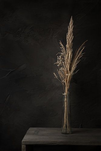 Dunkles Stillleben mit Trockenblumen auf altem Holztisch