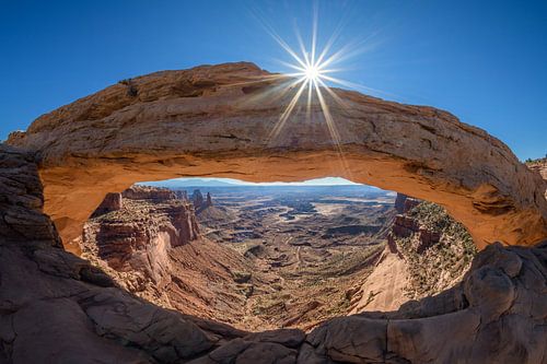 De zon streelt de Mesa Arch in Canyon Lands