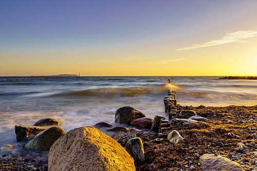 La plage de Dranske sur l'île de Rügen avec des vagues sur les épis au coucher du soleil (format pay