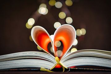 Liefdesverhalen. Boek met hartvormige bladzijden en feeënlichtjes bokeh van Martin Köbsch
