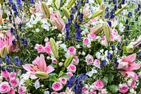 Strauß mit rosafarbenen Rosen, rosa Lilien und blauem Ritterspo