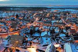 Aerial view of the snowy village of Huizen in North Holland at night by Eye on You