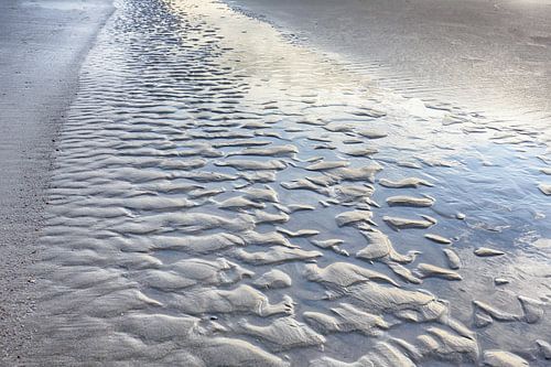 Ribbels langs het strand met spiegelend zeewater