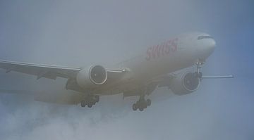 Le Boeing 777-300 de SWISS émerge du brouillard. sur Jaap van den Berg