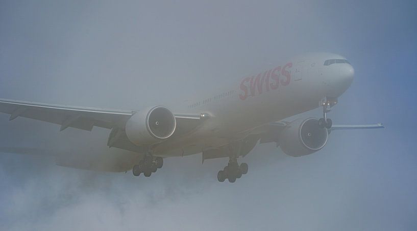 Le Boeing 777-300 de SWISS émerge du brouillard. par Jaap van den Berg