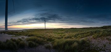 Duinlandschap in Denemarken met windturbines bij zonsondergang
