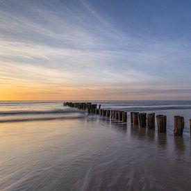 A peaceful sunset by the sea with wooden posts at De Kerf, Schoorl by Bram Lubbers