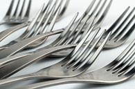 Abstract artistic photograph of cutlery, being eight lying forks against a white background by Tonko Oosterink thumbnail