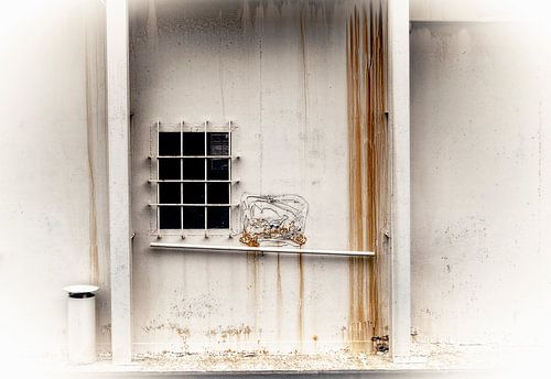 Roestig wit metalen gebouw met raam......