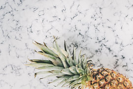 Tropische Ananas auf weißem Marmor von MADK