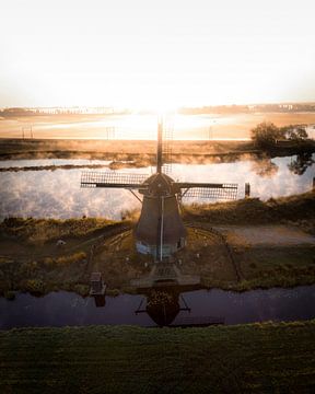 Windmill in morning mist at sunrise in the Netherlands by Ewold Kooistra