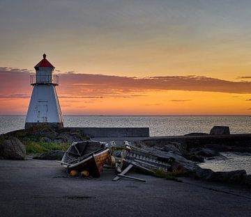 Sunset with assisted boat at the lighthouse on Vigra, Norway
