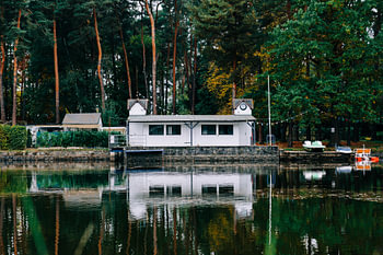 An old wooden house by the lake, reflected in the water
