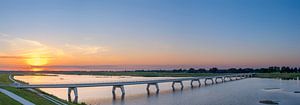 Panoramic view over a bridge over the Reevediep lake during sunset