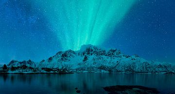 Noorderlicht boven een fjord en besneeuwde bergen in Noorwegen