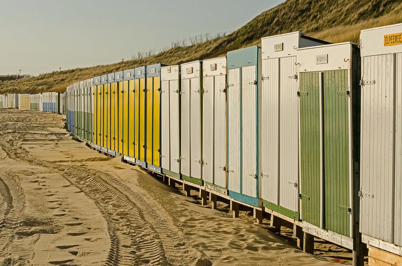 Strandhuisjes in scala aan kleuren op het strand van Tonko Oosterink