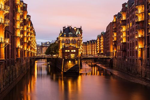 Speicherstadt Hamburg met de waterburcht. Lichtjes schijnen in de schemering.