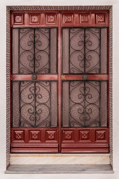 Porte colorée et ornée encadrée de carreaux de céramique par Dafne Vos