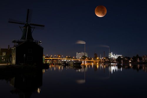 Blood moon over the river Zaan in Holland by Roelof Foppen