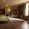 Slaapkamer in een oud verlaten herenhuis wat lijkt op een woonkamer tegelijkertijd. van Het Onbekende