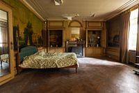 Slaapkamer in een oud verlaten herenhuis wat lijkt op een woonkamer tegelijkertijd.