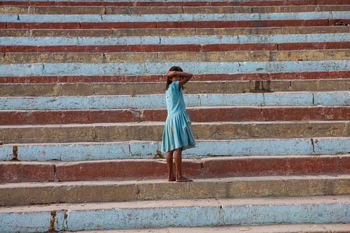 Indian girl poses on steps of Varanasi in India. Wout Kok One2expose