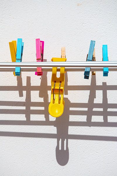 Colorful pegs on a washing rack in the sun by Harrie Muis
