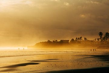 Wandelende mensen in de branding, zonsondergang Bali van Suzanne Spijkers