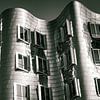 Façade des bâtiments Gehry dans le Media Harbour de Düsseldorf en noir et blanc avec ciel et nuages sur Dieter Walther