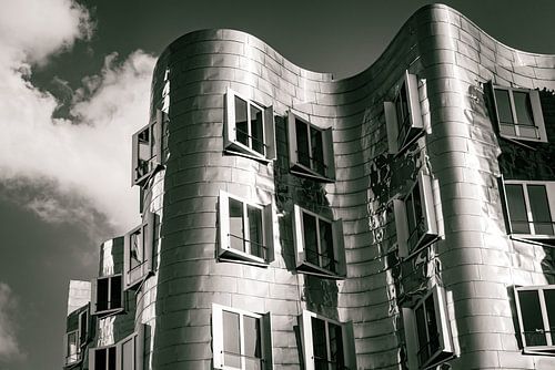 Gevel Gehry-gebouwen in de Mediahaven Düsseldorf in zwart-wit met lucht en wolken
