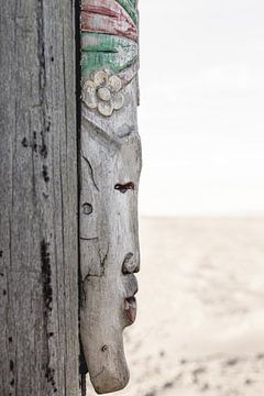 African mask on beach pole by Sandra Hogenes