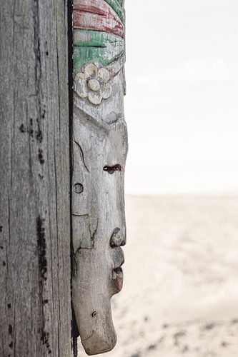 African mask on beach pole