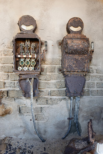 Rusty old electrical switch boxes on a brick wall