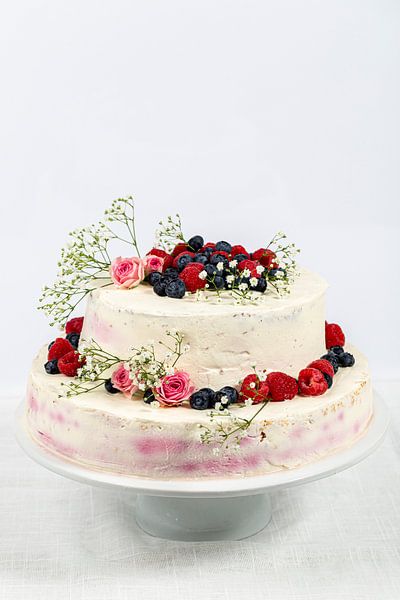 sommerliche frische zweistöckige Hochzeitstorte mit Beeren und Blumen verzierte festliche Sahnetorte von Thomas Heitz
