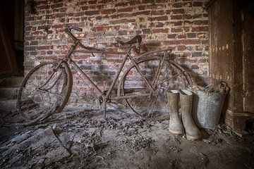 Roestige fiets met laarzen
