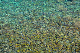 Klares Meerwasser in Sizilien mit bunten Kieselsteinen von Tomherkules