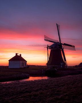 Un moulin à vent néerlandais sous un ciel crépusculaire coloré et au coucher du soleil sur Ewold Kooistra