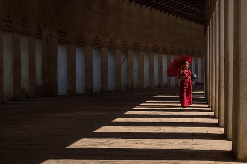 Jonge monnik in het licht van de ramen van een tempel in Bagan