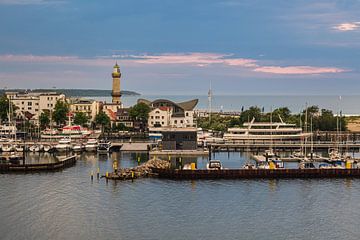 Zicht op Warnemünde met vuurtoren in de avond van Rico Ködder