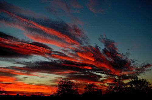 Vuurrode wolken bij zonsondergang
