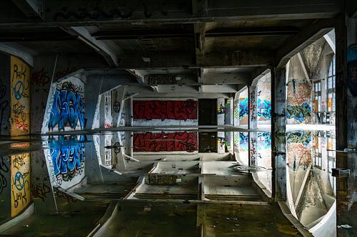 Abandoned hall with graffiti and perfect reflections - art and decay in a lost place