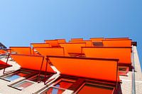Flatgebouw met oranje zonneschermen