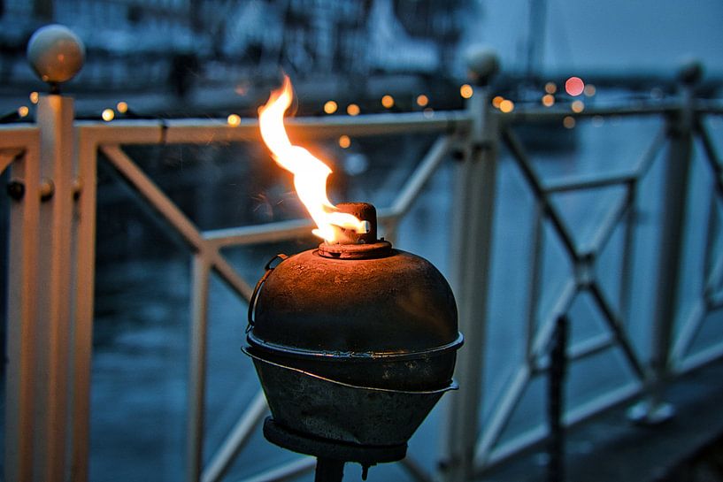 A burning oil lamp by the water in a relaxed atmosphere in Denmark. by Martin Köbsch