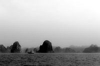 Een schip tussen de rotsen van Ha Long Bay