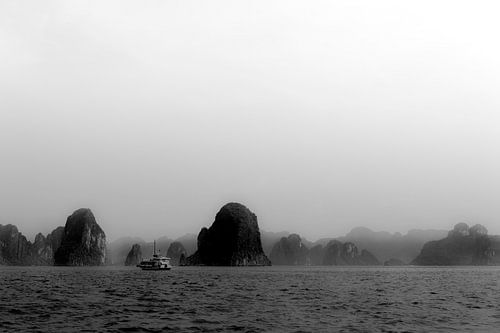 Een schip tussen de rotsen van Ha Long Bay