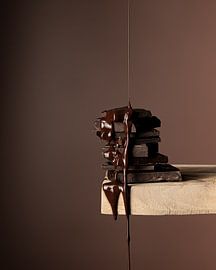 Dunkle Zartbitterschokolade, die langsam schmilzt und von einem Holzbrett tropft von Lucyna Smulders Photography